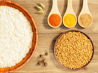 Rice, green cardamom, chili pepper, allspice, masala, fenugreek on brown wooden background. Indian cuisine, ayurveda, naturopathy, modern apothecary concept