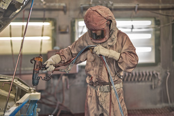 employee body painting workshop carries out painting of the internal elements of the car.