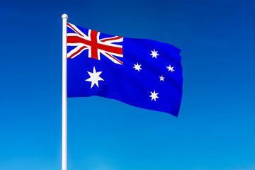 Obraz na płótnie Canvas Waving flag of Australia on the blue sky background
