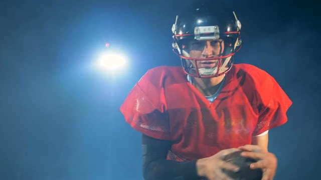American football player running on a football field, close up.
