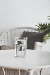 Glass of fresh water on table in room