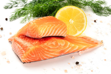 Slices of salmon with lemon and dill, close-up with salt and pepper, cooking fish, on a white background