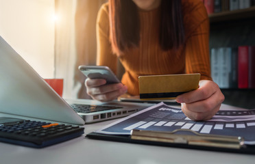 Businessman use credit cards to conduct financial transactions through phones, tablet, and laptop.