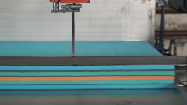 Average plan of machine with band saw, saw cuts paralon, worker rolls machine through saw, cuts pieces, production, household goods, paralon, process of manufacturing sponges for washing dishes