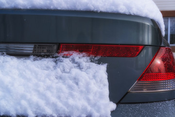 Close-up. Red taillight of a car under a layer of snow in winter