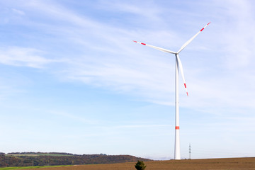 Fototapeta premium A windmill on a field with blue sky