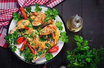 Turkish, georgian cuisine. Grilled fried roast Chicken Tabaka in plate on wooden background. Top view, overhead