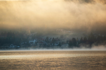 Fototapeta premium Lovely autumnal landscape with fog over the lake.