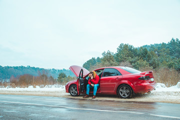 Obraz na płótnie Canvas man sitting in car calling for help. break down at winter speedway