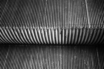 Detail of underground escalator step black and white