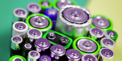 Many different types used or new battery, rechargeable accumulator, alkaline batteries on color background.