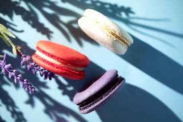 Gordijnen Cakes macaroon or macaron with lavander plant on blue background, close up © Софья Берняк