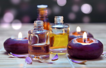 Obraz na płótnie Canvas bottles of oil and candle on blur lights background