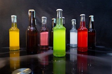 Many flavors of soda pop on table in black background