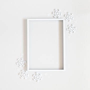 Christmas composition. Photo frame, snowflakes on pastel gray background. Christmas, winter, new year concept. Flat lay, top view, copy space, sguare