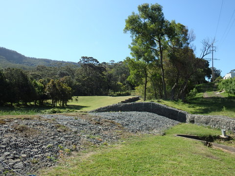 Stone walls under steel mesh creating a spillway for rain water  flood and erosion prevention