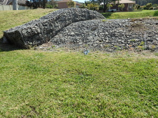 Stone walls under steel mesh creating a spillway for rain water  flood and erosion prevention