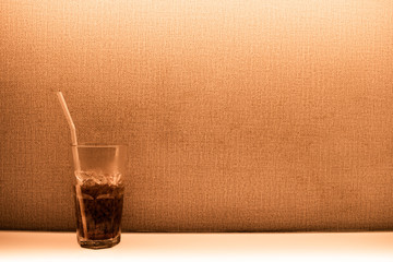 The beverage contained half a glass placed beside the walls.