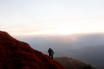 Fototapeta premium tourist at the top of the mountain During sunset