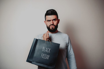 Black friday image with space for text. Bkack friday sale flat lay. Black friday bag. Bearded man...