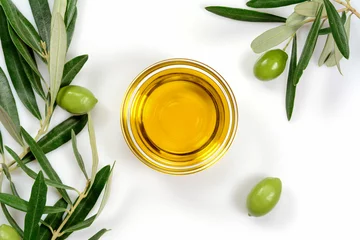 Foto auf Acrylglas Olive oil. Greek olive oil in glass transparent bowl with branches with leaves and olives, with copy space. Close-up, on white background. © JethroT