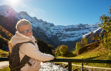 Naklejka premium smiling boy with backpack in autumn mountains (cirque de Gavarnie)