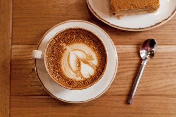 Cup of coffee on wood table, close-up. Cozy pastime in the cafe