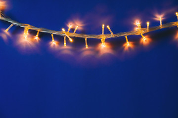 Blue background with illuminated lights of garland