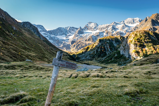 Wooden signpost at hiking path at Timmelsjoch and Texelgruppe nature park leading to the Seebersee with the alpine mountains in the background