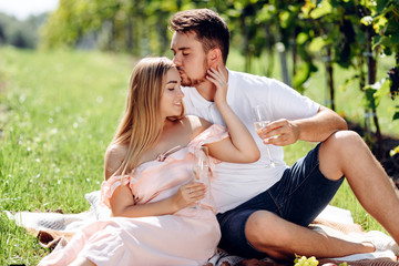 Young couple kissing in a vineyard.