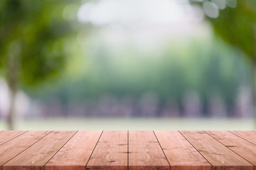 Empty wood table top and blurred green tree and lawn in public park background - can used for display or montage your products.