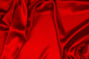Red silk or satin luxury fabric texture can use as abstract background. Top view.
