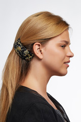 Cropped side view shot of blond girl with long hair, wearing black jacket. She pulling her hair...
