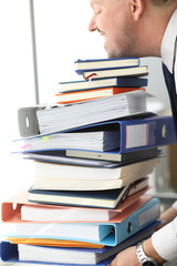Office worker trying to lift huge pile of documents