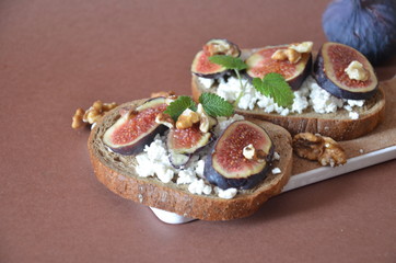 Sandwiches with ricotta, fresh figs, walnuts and honey. Canape or crostini with toasted baguette, cheese, jam, Delicious appetizer, ideal as an aperitif. Selective focus