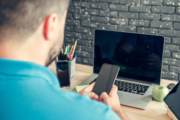 Young man businessman sitting at his working table in office
