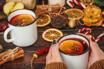 Woman holding cup with mulled wine in her hands