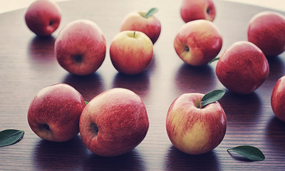 Fresh apples on a wooden board. Harvest of red apples. Fruits and cinnamon on the table.