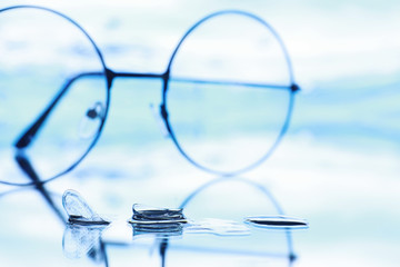 Tools for vision correction. Glasses and lenses with diopters on the background of splashes and...