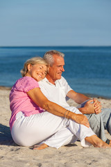 Fototapeta na wymiar Happy Senior Couple Sitting Together on a Tropical Beach