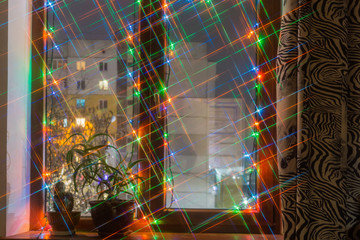 Modern wooden window decorated with Christmas lights in evening time