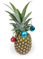 Whole fresh pineapple decorated with Christmas balls on white background
