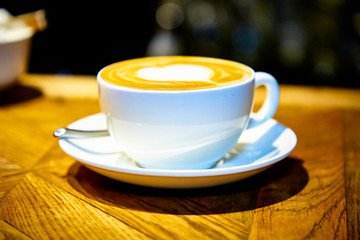 Heart on a cappuccino Cup on a wooden table