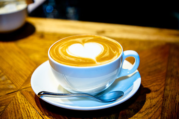 Heart on a cappuccino Cup on a wooden table