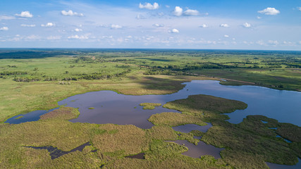 Aerial view of typical Pantanal landscape with lagoons, rivers, meadows and forest, blue sky and...