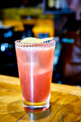 Red cocktail with Bay leaf poured into a tall glass