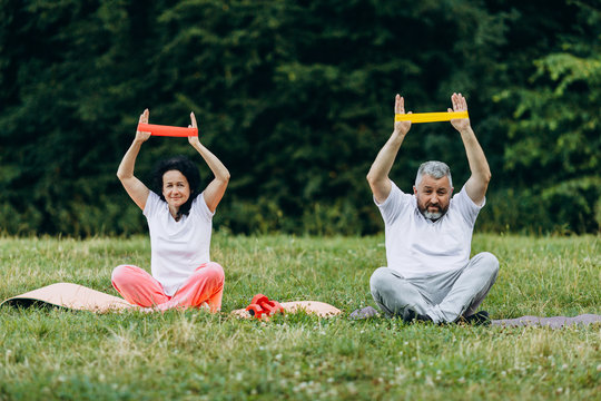 Middle age woman and man  taking exercise with a tape together.- Concept sport - Image
