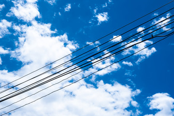 Fototapeta premium The background of electrical wire cable with blue sky for energy power consumption concept and idea