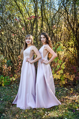 Obraz na płótnie Canvas Two young princess wearing nice beige dress in autumn park. Fashion photo.