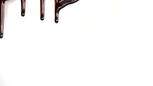 Real chocolate streams flows down on white background. Liquid chocolate. Seamless looping